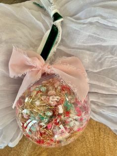 an ornament filled with lots of candy on top of a white cloth bag