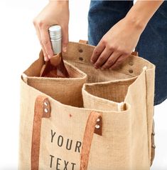 a person holding a bottle in a jute bag with the words your text on it