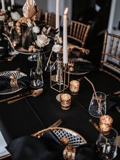 the table is set with black and gold decorations