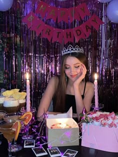 a woman sitting at a table in front of a birthday cake with candles on it