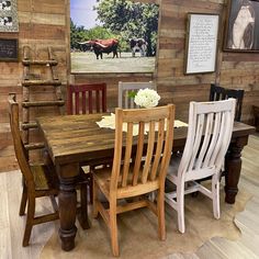 a dining room table with chairs and pictures on the wall behind it in a rustic setting