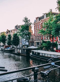 there is a bike parked on the side of the street next to the water and buildings