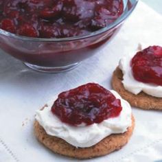 two cookies with whipped cream and cranberry sauce