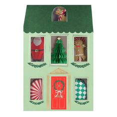 a green cardboard house with christmas decorations in the windows