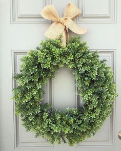 a wreath with a bow hanging on the front door