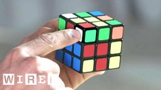 a person holding a rubik cube in their hand