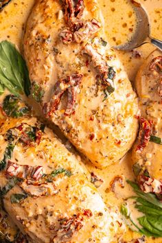 closeup of chicken with sauce and herbs on top in a skillet, ready to be eaten