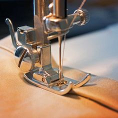 the sewing machine is stitching something with it's needle and thread ends up