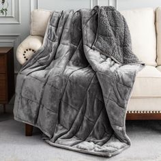 a gray blanket sitting on top of a couch