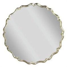 a round mirror with an ornate design on the top and bottom, is shown in gold