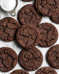 chocolate cookies are arranged on a piece of paper next to a pair of scissor