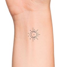 a small sun and moon tattoo on the left side of the wrist is shown in black ink