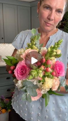 a woman holding a bouquet of flowers in her hands and looking at the camera with surprise