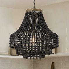 a black chandelier hanging from the ceiling in a kitchen with white tile walls