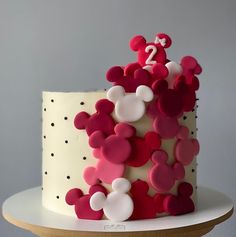 a white and red cake with mickey mouse decorations