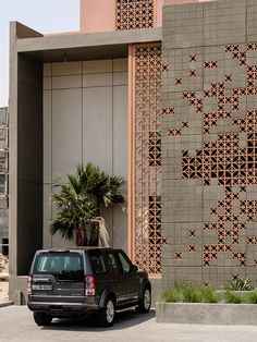 a black suv parked in front of a building with an intricate design on it's side