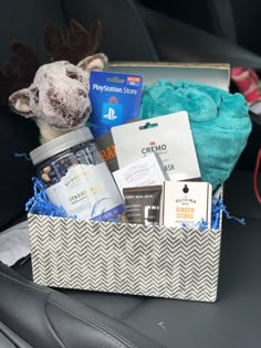 a stuffed animal sitting in the back seat of a car filled with personal care items