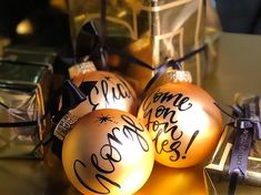 three orange christmas ornaments with writing on them