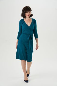 a woman in a teal dress is walking