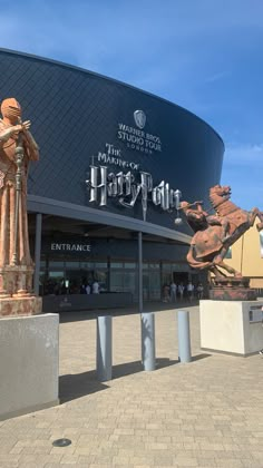 the entrance to harry potter's studio at universal studios, with statues in front