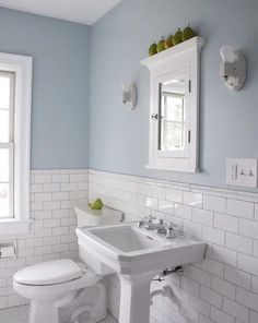 a bathroom with blue walls and white tile on the floor is featured in this post