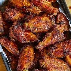 chicken wings in tin foil sitting on top of a wooden table