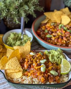 two bowls filled with rice, beans and guacamole next to tortilla chips