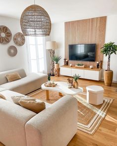 a living room filled with furniture and a flat screen tv on top of a wooden table