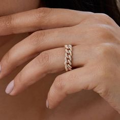 a woman's hand with a gold ring on her left hand and the other hand holding