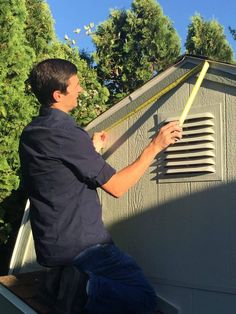 a man measuring the height of a shed