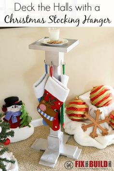 christmas stockings hanging on a stand with other ornaments and decorations in the corner next to it