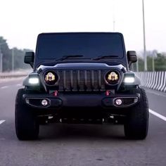 a black jeep is driving down the road