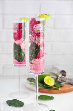 two glasses filled with pink and green drinks