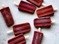 five popsicles are lined up on a table with toothpicks sticking out of them