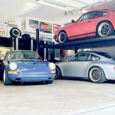 two cars are parked on top of each other in a garage with three lifts above them