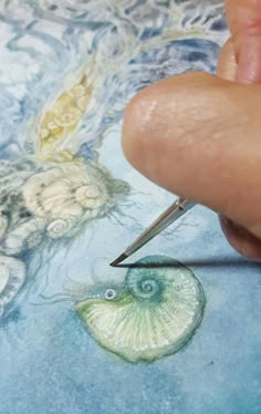 a person is using a needle to draw an image