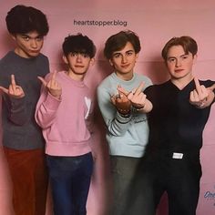 three young men standing next to each other in front of a pink wall with the words hearttopper blog written on it