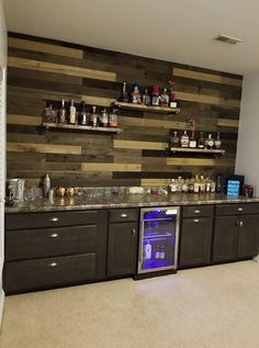 an empty bar with shelves and bottles on the wall behind it in a room that has carpeted flooring