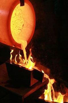 a person pouring something into a bowl on fire