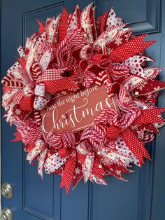 a red and white christmas wreath on a blue door