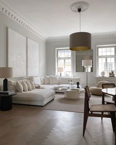 a living room filled with white furniture and lots of windows