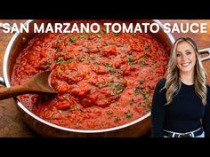 a woman standing in front of a large pot filled with food and the words san maraano tomato sauce