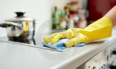 a person in yellow gloves is cleaning the counter