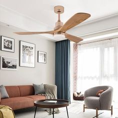 a living room with a couch, chair and ceiling fan in it's center