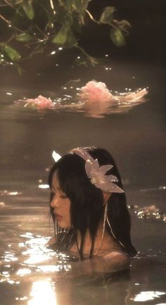 a woman in the water with flowers on her head