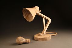 a wooden desk lamp sitting on top of a table next to a piece of wood