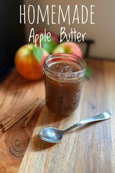 homemade apple butter in a glass jar with spoon on the table next to apples and cinnamon sticks