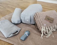 several pillows and blankets laid out on the floor next to each other with tags attached