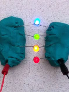 a pair of blue mittens sitting on top of a white floor next to a string of lights