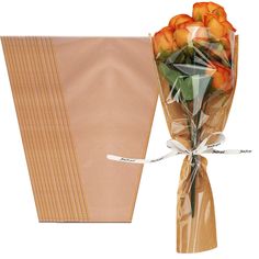 a bouquet of orange roses wrapped in cellophane and tied to a piece of paper